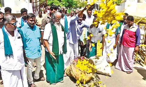 Farmers dump flowers in front of the Tiruchy Collectorate.