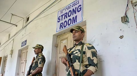 Security personnel stand guard outside a strong room