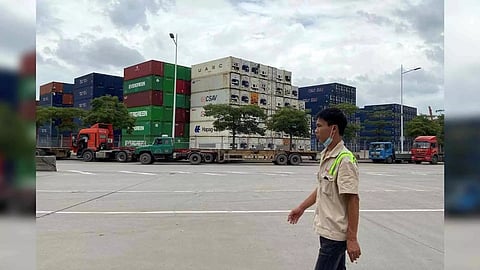 A man walks past containers at a port in Shenzhen, Guangdong province, China (Photo: Reuters)