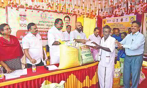 Collector Johny Tom Varghese distributing kuruvai package to a farmer on Saturday