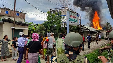 Smoke billows from a house torched by unidentified miscreants in Manipur
