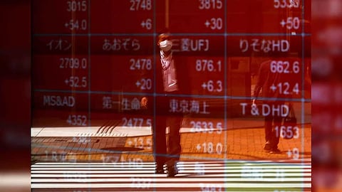 A man is reflected on an electric stock quotation board outside a brokerage in Tokyo, Japan (Photo: Reuters)&nbsp;