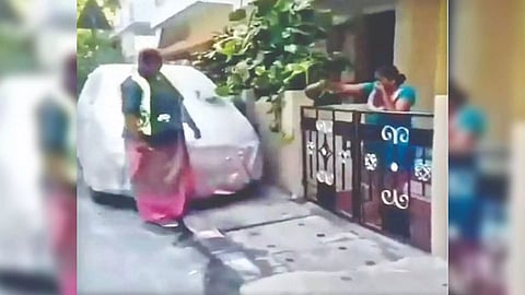 Bengaluru woman distancing sanitation workers in front of her house
