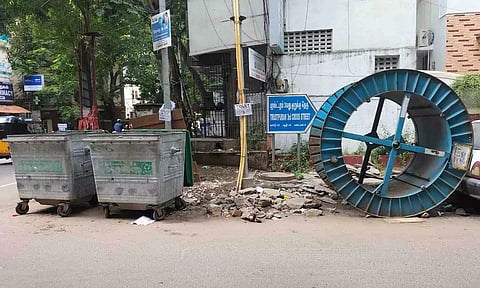 Garbage bins, broken slabs and a spool placed dangerously on the road