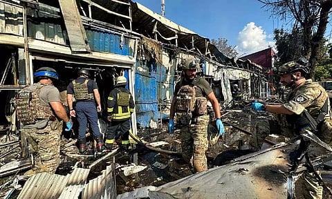Police officers and rescuers inspect the site of a Russian military strike (Reuters)