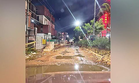 The unlaid road full of potholes and stagnated rainwater poses safety risk for commuters