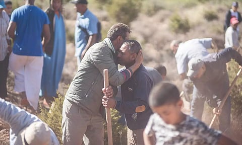 People console each other while digging graves for quake victims near Marrakech.