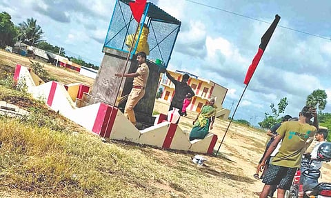 Cops washing the bust of Periyar statue smeared with cow dung in Vadachithur village near Coimbatore on Wednesday