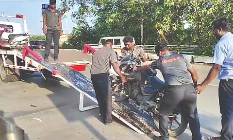 Vehicles that were not parked in designated space being removed. Violators were also fined