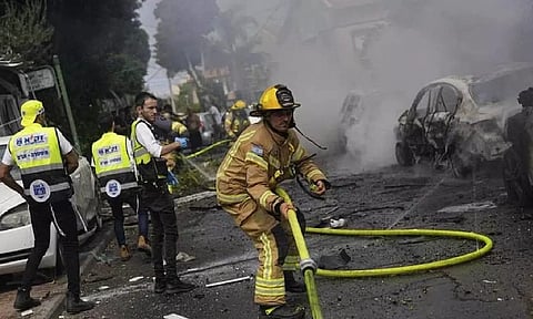 Israeli firefighters extinguish fire at a site struck by a rocket fired from the Gaza Strip, in Ashkelon, southern Israel, Monday, Oct. 9, 2023.