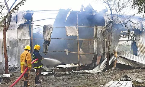 Fire personnel dousing fire after an explosion at a cracker shop-cum-packing unit in Rengapalayam near Sivakasi.