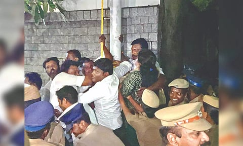 BJP cadre preventing police from removing flagpole in Chennai.
