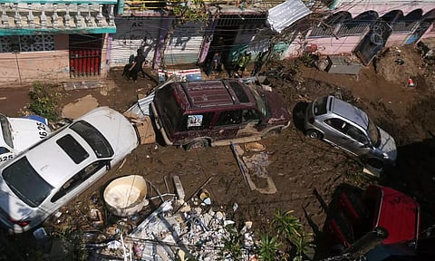 People stand amidst damaged items and debris in the mud, Acapulco, Mexico (Photo: Reuters)
