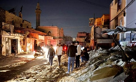 Palestinians stand on the street after an Israeli raid, in Jenin refugee camp in the Israeli-occupied West Bank. (Reuters)
