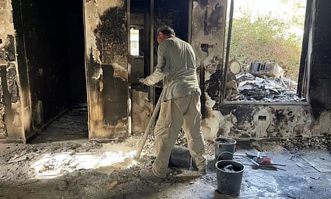 Archeologists from the Israel Antiquities Authority sift through the remains of burnt-out houses to look for human remains (Image: ANI)