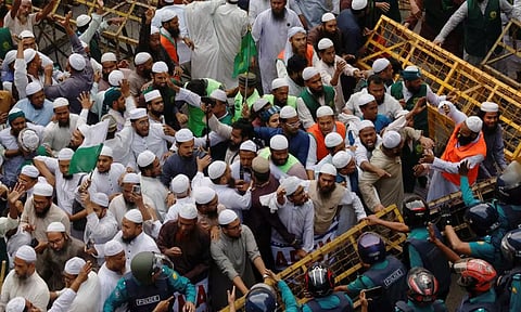 Members of the Islami Andolan Bangladesh, a political party, try to remove barricades as they join in a mass protest march towards the Election Commission, ahead of the election schedule declaration, in Dhaka. (Reuters)&nbsp;