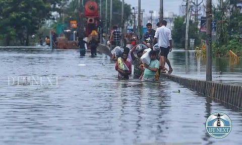 Residents of Perumbakkam wading through a waterlogged road as it is the only way out. (Justin George)