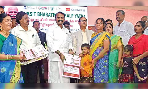 L Murugan distributing ‘selvamagal’ savings scheme to a child in Coimbatore