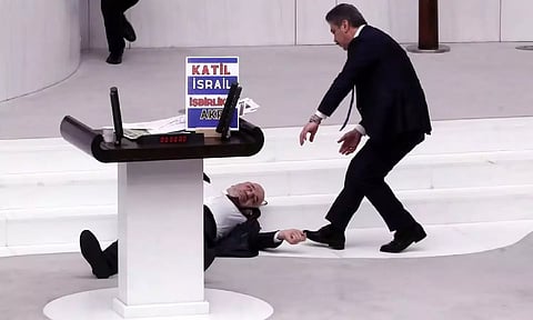 &nbsp;Turkey's opposition Felicity Party lawmaker Hasan Bitmez lies on the floor next to a stand with a placard after collapsing