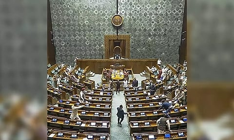 A visitor jumps into the Lok Sabha chamber from the public gallery on December 13. (Sansad TV/PTI)