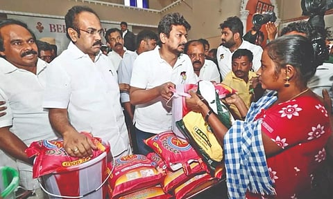 Minister Udhayanidhi Stalin distributing relief materials to flood-hit people in Tirunelveli on Monday.