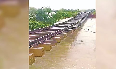 The heavily eroded railway track hanging dangerously near Srivaikuntam station on Monday.