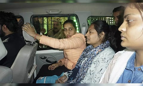 Neelam Azad, center, an accomplice in Wednesday’s security breach in the Indian parliament, is escorted to be taken into police custody, in New Delhi. (AP)