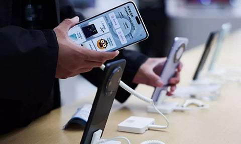 A person checks a Huawei Mate 60 Pro smartphone displayed at a Huawei flagship store in Beijing, China (Reuters)