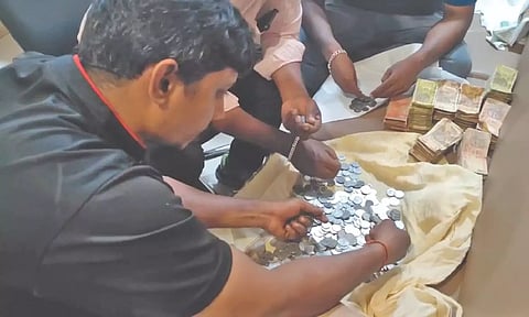 Staff at vehicle service centre counting the coins