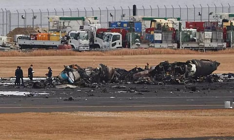 Officials investigate a burnt Japan Coast Guard aircraft after a collision with Japan Airlines (Reuters)