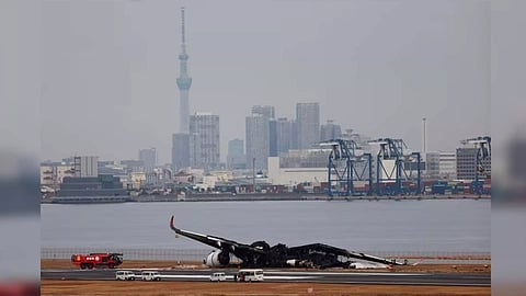 Officials investigate a burnt Japan Airlines (JAL) Airbus A350 plane after a collision (Reuters)
