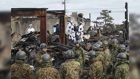 Japanese Self Defense Force members search the collapsed houses in Wajima (AP)