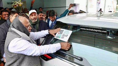 Congress president Mallikarjun Kharge affixes the newly launched logo of ‘Bharat Jodo Nyay Yatra’ on the backside of a car, in New Delhi. (ANI)