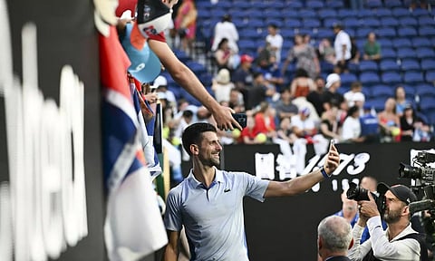 Novak Djokovic poses for selfies with fans after his win over Taylor Fritz