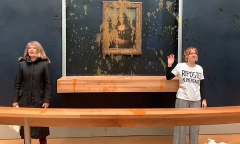 Two climate activists have hurled soup at the glass protecting the Mona Lisa at the Louvre Museum in Paris (AP)