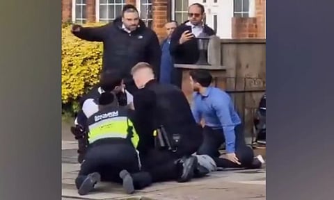 A screengrab of video showing police and others detaining the man in Golders Green, London (@CST_UK)