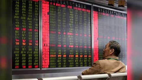 An investor watches a board showing stock information at a brokerage office in Beijing, China. (Reuters)