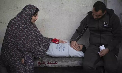 Palestinians mourn a child killed in the Israeli bombardment of the Gaza Strip at a hospital morgue in Rafah, Monday, Feb. 12, 2024. (AP)