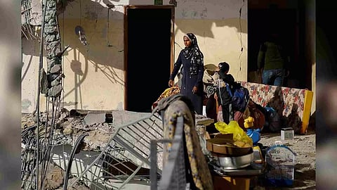 A Palestinian woman and a child look on at the site of an Israeli air strike on a building (Reuters)