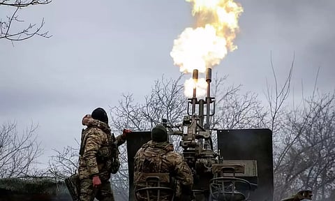 Ukrainian servicemen fire an anti-aircraft cannon near Bakhmut