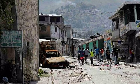 People walk through the damaged neighborhood which was deserted due to gang violence (Reuters)