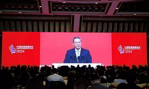 Journalists watch a giant screen showing live-streaming footage of Chinese Premier Li Qiang delivering a speech at the opening ceremony of China Development Forum (CDF) 2024, in Beijing, China March 24, 2024. (REUTERS)