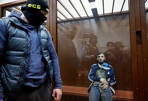 Dalerdzhon Mirzoyev, a suspect in the shooting attack at the Crocus City Hall concert venue, sits behind a glass wall of an enclosure for defendants at the Basmanny district court in Moscow (Reuters)