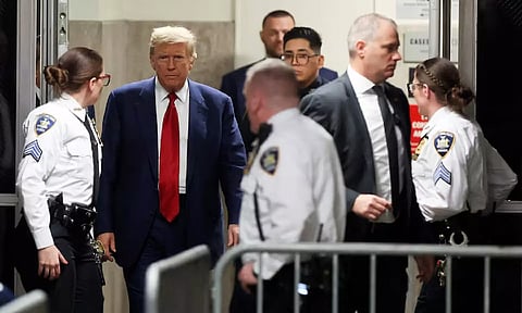 Donald Trump walks in the hallway outside a courtroom