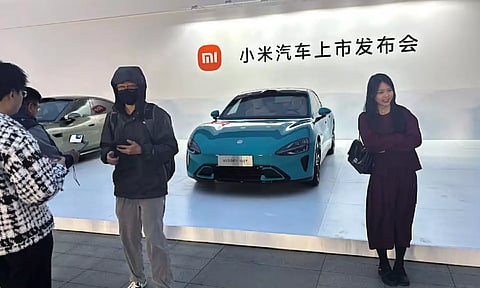 Xiaomi's first electric vehicle SU7 that is displayed outside the avenue for the car's launch event