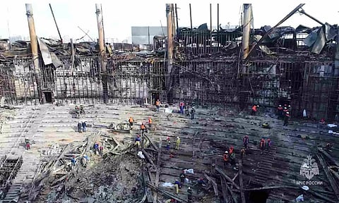 Members of the Russian Emergencies Ministry and workers remove debris inside the burnt-out Crocus City Hall. (Reuters)