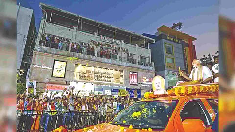 Modi showing the symbol Lotus to people during roadshow in city