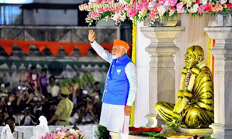 Prime Minister Narendra Modi waves at supporters before a road show ahead of Lok Sabha polls (PTI)