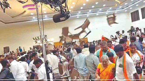 Political functionaries flinging chairs at one another in what appears to be a large conference hall has gone viral