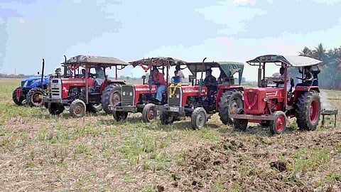 Tractors lining up with attached ploughs during a Nal Er Pootuthal event in Thanjavur on Monday